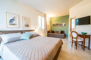 ein Schlafzimmer mit einem Bett, einem Tisch und einem Sofa in der Unterkunft IL NIDO DEGLI USIGNOLI in Peschiera del Garda