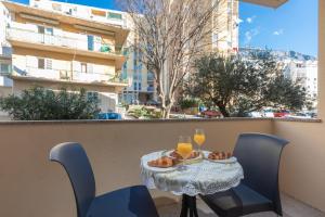 a table and chairs on a balcony with drinks and food at Luxury apartman BOSSE in Makarska