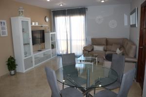 uma sala de estar com uma mesa de vidro e um sofá em Spectacular views. All new with free parking em Córdoba