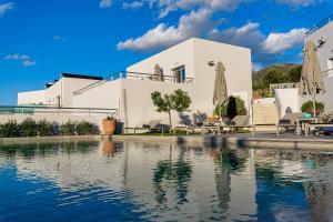 a white house with a swimming pool in front of it at Sunset Elafonisi Apartments in Livadia