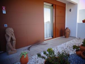 una entrada a un edificio con una estatua y algunas plantas en Suites da Ria, en Mexilhoeira Grande