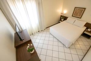 a hotel room with a bed and a window at Hotel Ryan in Balneário Camboriú