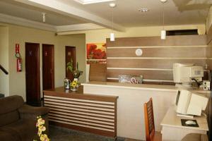 a living room with a kitchen with a counter at Hotel Morada do Sol in Araxá +13 photos