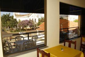 a room with a table and chairs on a balcony at Hotel Morada do Sol in Araxá