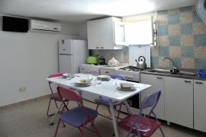 a kitchen with a white table with chairs and a stove at Casa Taro in Noto