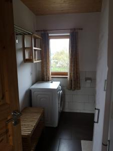 a small bathroom with a washing machine and a window at 1Austragshaus Andermichlhof in Geltendorf