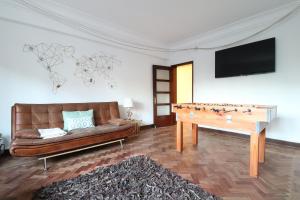 a living room with a couch and a ping pong table at Central Terrace in Lisbon for Groups in Lisbon