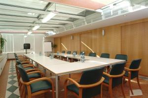 a conference room with a long table and chairs at Airporthotel Salzburg - Hotel am Salzburg Airport in Salzburg
