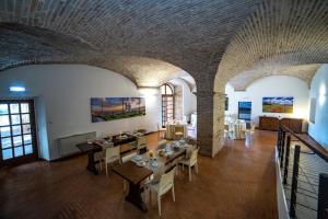 uma grande sala com mesas e cadeiras num edifício em il Monastero di Bevagna em Bevagna