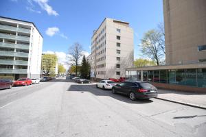 a street with cars parked on the side of the road at Rental Apartment Kaski Vuokramajoitus Oy in Turku