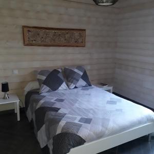 a bed in a room with two tables and a bedspread at Le Barail 31 in Couret