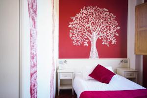 una camera da letto con una parete rossa e un murale sull'albero di Hotel Il Crinale a Grizzana