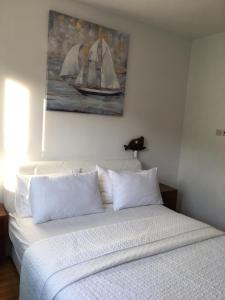 een slaapkamer met een wit bed en een schilderij aan de muur bij Apartment Marina Komiza in Komiža