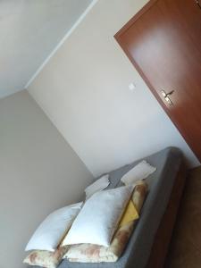a small bed with white sheets and pillows in a room at Perełka in Władysławowo