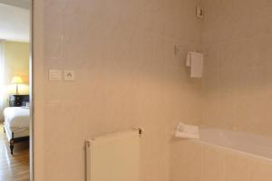 La salle de bains est pourvue d'une baignoire et d'un lit. dans l'établissement COLMAR - Appartement "LE ROESSELMANN 2" -, à Colmar