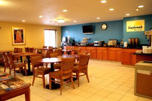 a restaurant with tables and chairs and a kitchen at Days Inn & Suites by Wyndham Bloomington/Normal IL in Bloomington