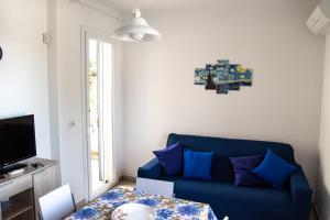 a living room with a blue couch and a table at Villa Imma in Torre Lapillo