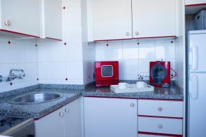 uma pequena cozinha com um lavatório e um aparelho vermelho em Sunset Dream Bajamar GREAT VIEWS em Baja Mar