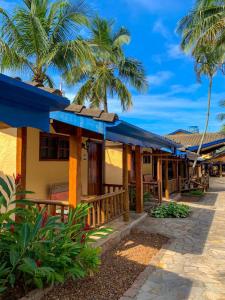 um resort na praia com palmeiras em Pousada Tambayba em Maresias