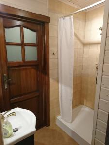 W łazience znajduje się prysznic i biała umywalka. w obiekcie Mazurski Staw w Gołdapi