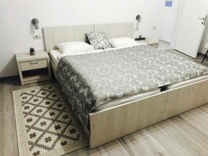 a large bed in a bedroom with two night stands at Abby in Câmpulung Moldovenesc