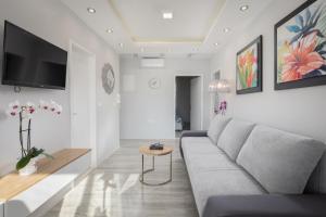 a living room with a couch and a tv on the wall at Luxury apartman BOSSE in Makarska