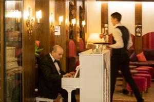 Ein Mann im Anzug, der an einem Tisch mit einem Laptop sitzt. in der Unterkunft Sporthotel St. Anton in Sankt Anton am Arlberg + 76 Fotos