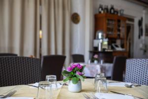 stół z wazonem z fioletowymi kwiatami w obiekcie Maria Tindara "La Locanda" w mieście Vulcano