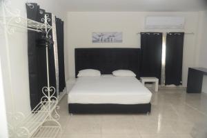 a bedroom with a bed with white sheets and black curtains at Red Sea Hotel in Eilat