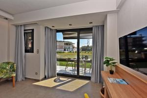 a living room with a large glass door with a table at CALLISTA VIEW in Flogita