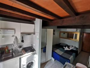 Habitación pequeña con cama y lavadora. en Piccola Stella, en Parma