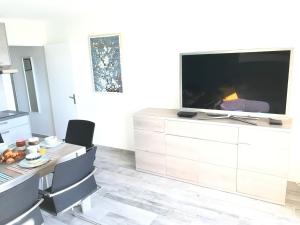 A television and/or entertainment centre at Appartement 3 pieces, refait a neuf, haut standing, piscine, mer a pieds