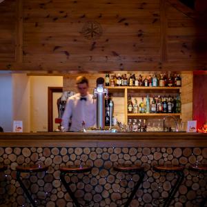 a man standing behind a bar with a bartender at Hotel SNOW CHILL in Risoul