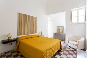 ein Schlafzimmer mit einem gelben Bett und einem Stuhl in der Unterkunft Le Luminarie - Creative Residence in Balestrate