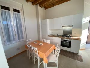 een keuken met een houten tafel en witte kasten bij Novi Homes in Milaan