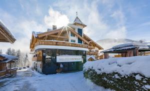 eine Ski-Lodge mit Schnee auf dem Boden in der Unterkunft Wellnessresort Seiwald **** Superior in Going