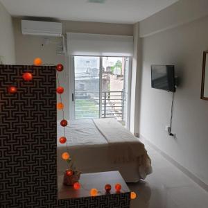 Un dormitorio con una cama y una ventana con naranjas. en Lo de Ale en San Miguel de Tucumán
