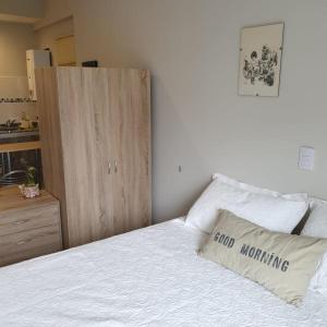 1 dormitorio con 1 cama y armario de madera en Lo de Ale en San Miguel de Tucumán