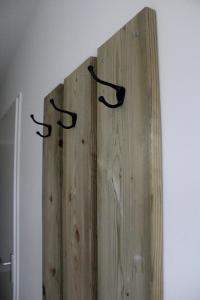 ein Stück Holz mit drei Griffen an der Wand in der Unterkunft Landzicht in Woubrugge