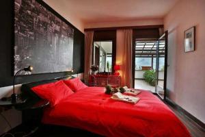 a red bed in a bedroom with a large window at Villa la Grona in Menaggio