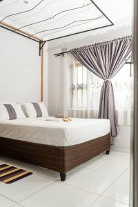 a bedroom with a canopy bed with a window at KhayaLethu Vic Falls in Victoria Falls