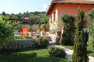 a garden with chairs and trees and a house at Simon Vendégház Balatongyörök in Balatongyörök