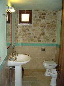 a bathroom with a sink and a toilet and a window at Dimora Antico Forno Soprano in Maschito