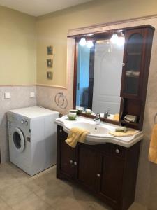 a bathroom with a sink and a washing machine at Dreamy Sunsets Faros in Karistos