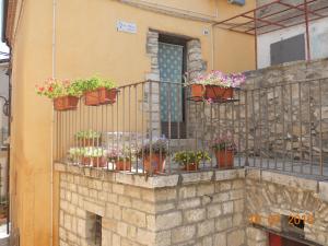 a balcony with potted plants on a building at Dimora Antico Forno Soprano in Maschito