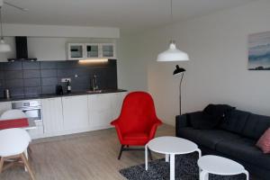 sala de estar con sofá y silla roja en Veldhuis, en Woubrugge