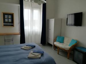 a bedroom with a bed and a television at Domo Sul Porto in Stintino