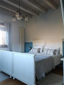 una camera da letto con un letto bianco con cuscini bianchi di La Porta Accanto B&B a San Vito di Leguzzano