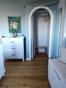 sypialnia z białą komodą i łukowymi drzwiami w obiekcie La Porta Accanto B&B w mieście San Vito di Leguzzano
