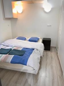 ジュイ・アン・ジョザにあるAppart'Village Jouy La longèreのベッドルーム1室(青と白のシーツが備わるベッド1台付)